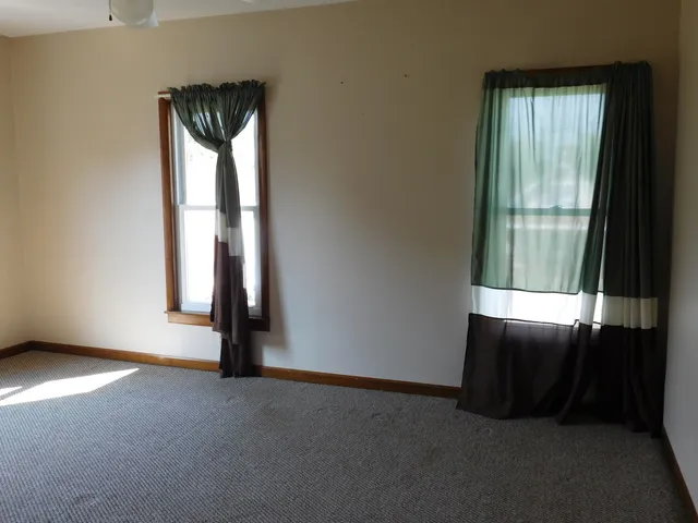 an empty room with windows and closet