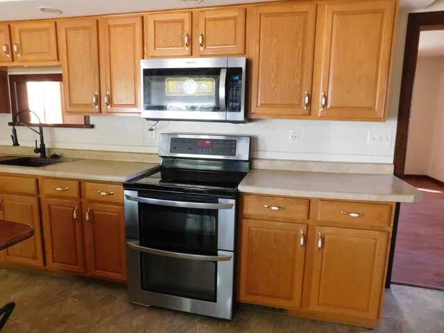 a kitchen with granite countertop cabinets stainless steel appliances and a sink