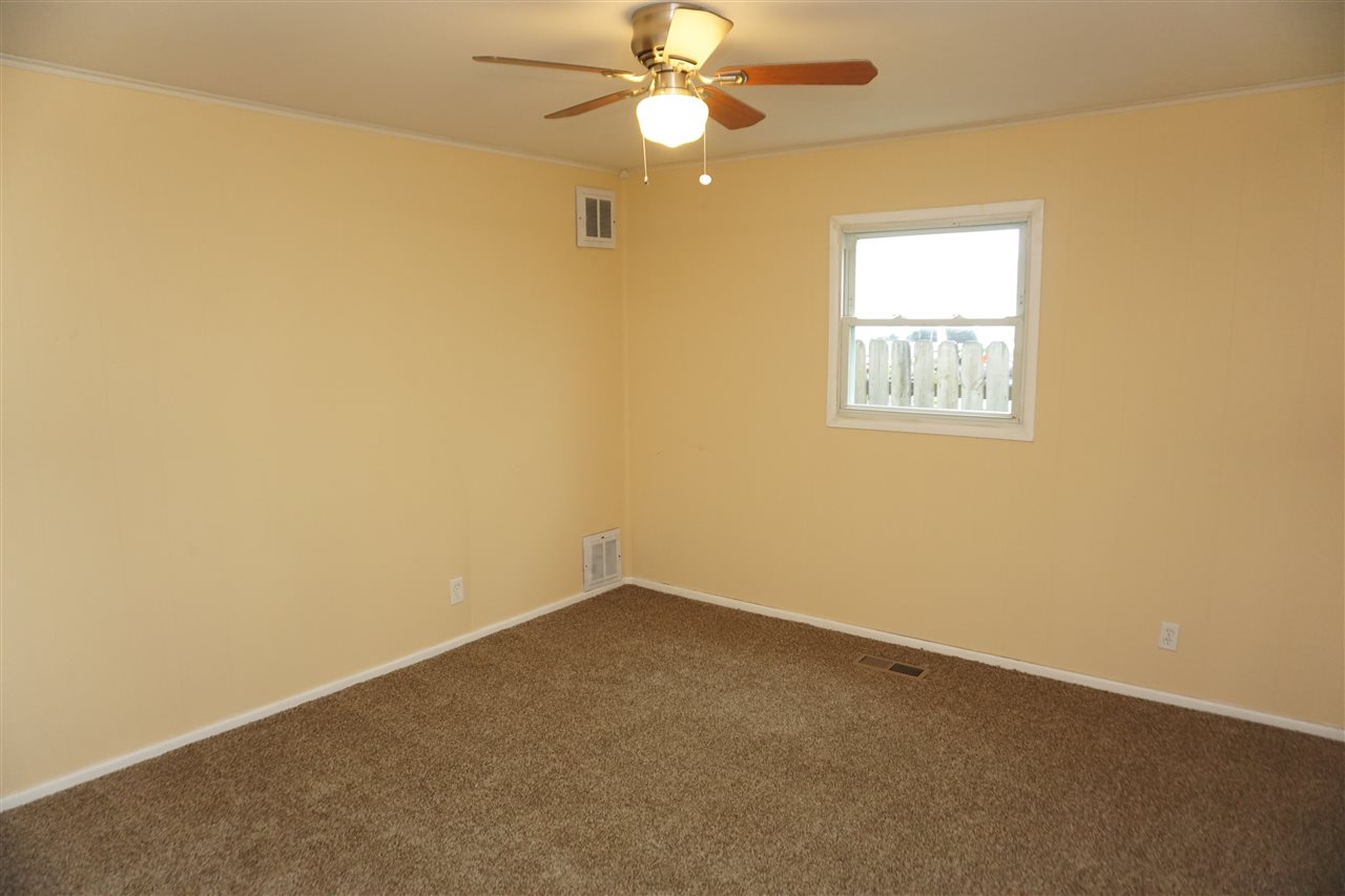 7908 Randy Road Machesney Park, IL 61115 - Photo 3 of 16 an empty room with a window and a fan
