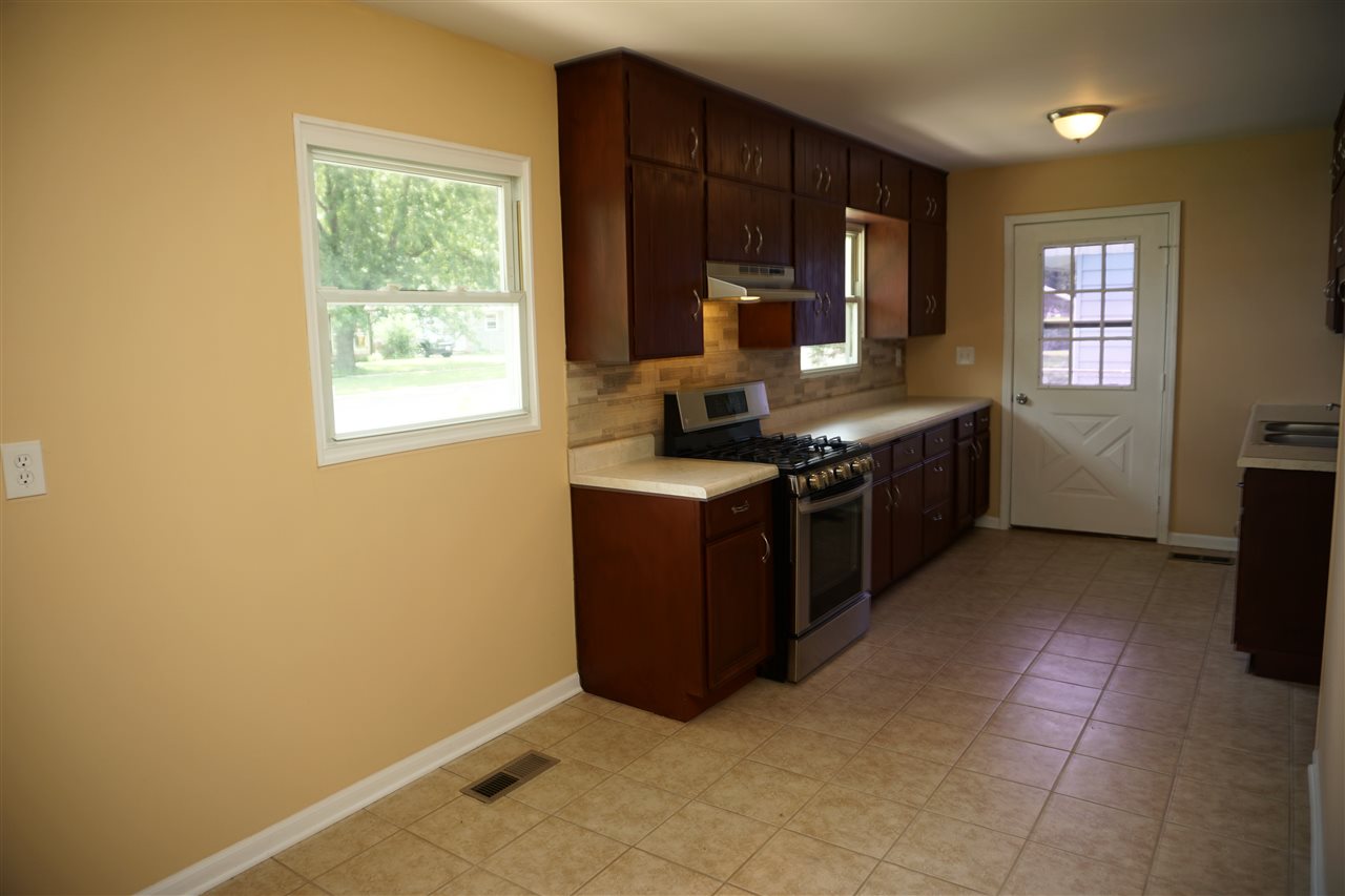 7908 Randy Road Machesney Park, IL 61115 - Photo 8 of 16 a kitchen with stainless steel appliances granite countertop a stove a sink and a microwave