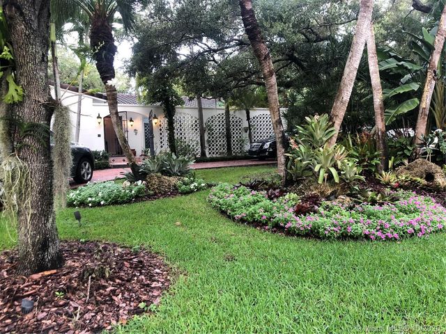 a view of a garden with large trees