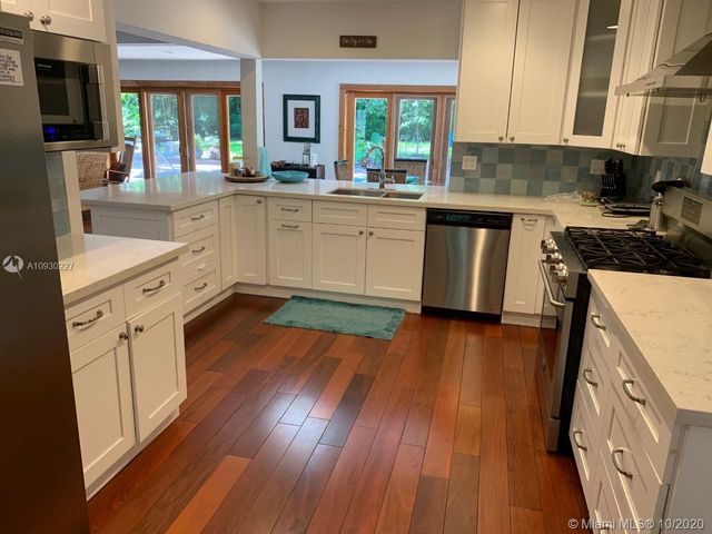a kitchen with wooden floors and appliances
