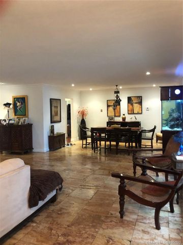 a living room with furniture and a dining table with kitchen view
