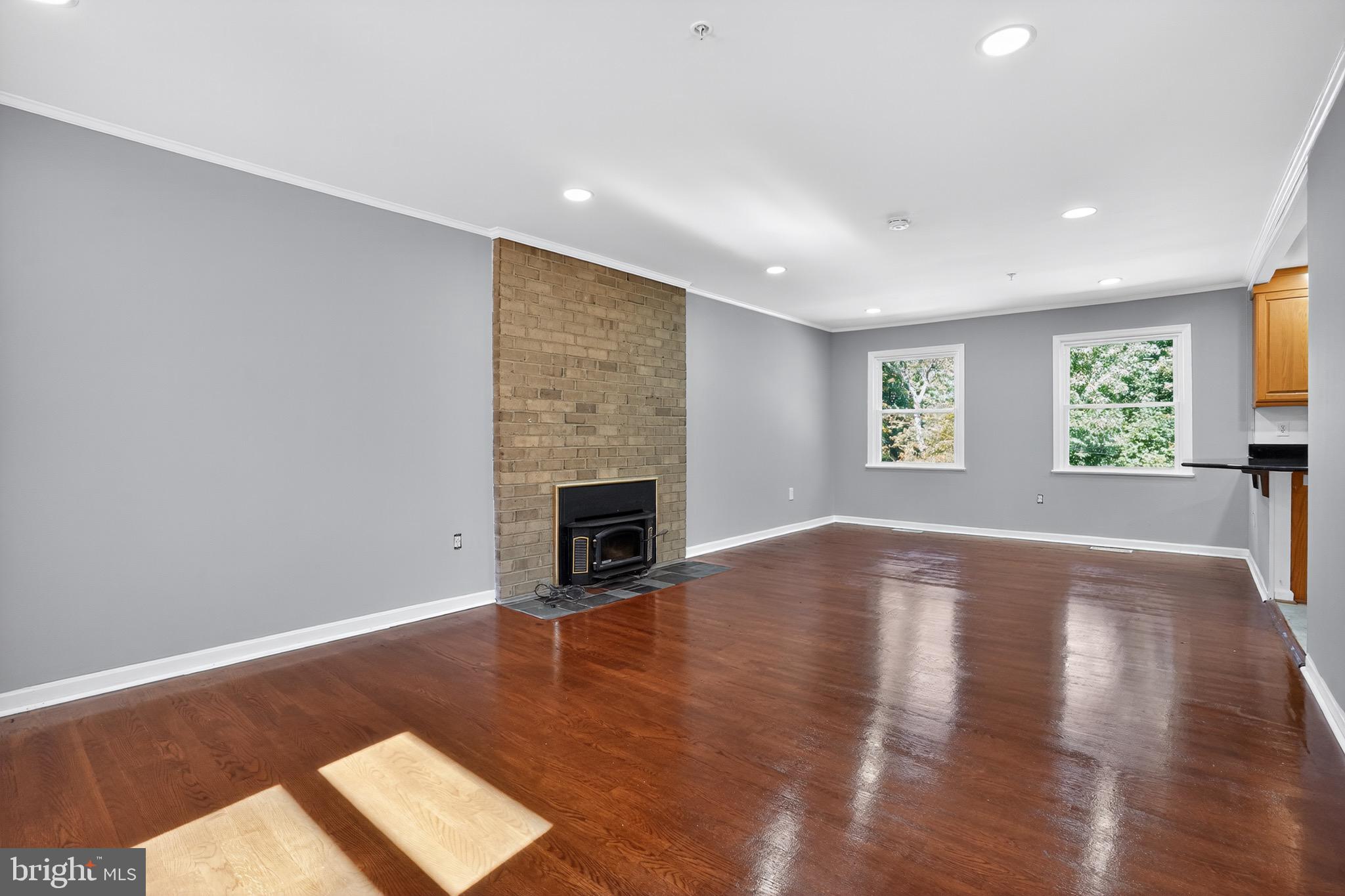 11308 Chantilly Lane Bowie, MD 20721 - Photo 27 of 30 a view of empty room with wooden floor and fireplace