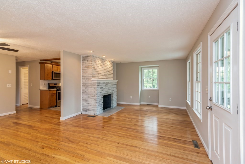106 Martin Farms Road Hampden, MA 01036 - Photo 2 of 34 a view of empty room with wooden floor and fireplace