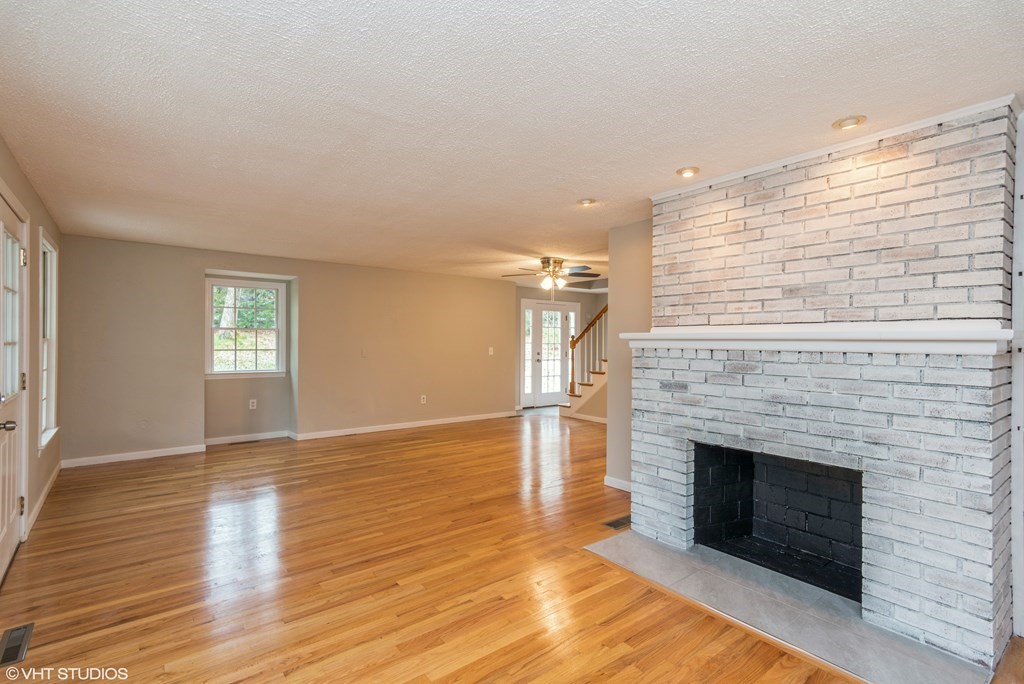 106 Martin Farms Road Hampden, MA 01036 - Photo 5 of 34 a view of an empty room with wooden floor fireplace and a window