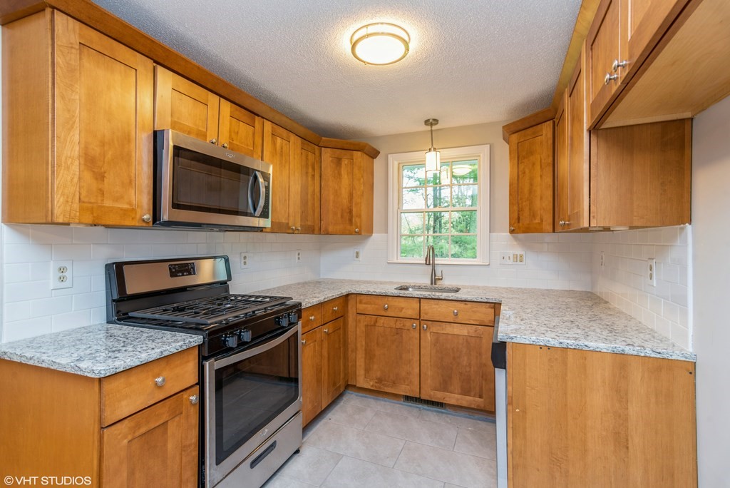 106 Martin Farms Road Hampden, MA 01036 - Photo 7 of 34 a kitchen with stainless steel appliances granite countertop a stove top oven a sink dishwasher and a microwave oven on the blue kitchen countertops
