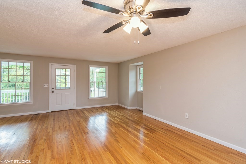 106 Martin Farms Road Hampden, MA 01036 - Photo 8 of 34 an empty room with wooden floor fan and windows
