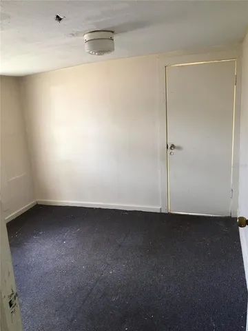 a view of a room with a ceiling fan and wooden floor