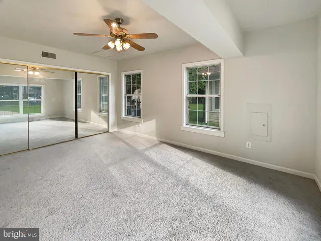 a view of a livingroom with a ceiling fan and window