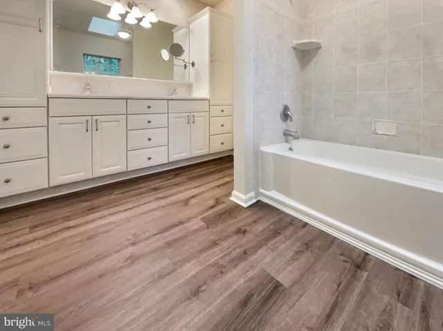 a spacious bathroom with a granite countertop sink and a mirror