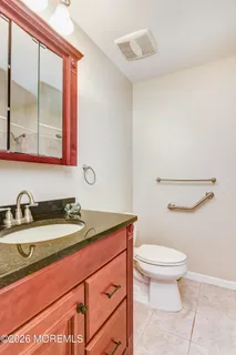 a bathroom with a granite countertop sink a toilet and a mirror