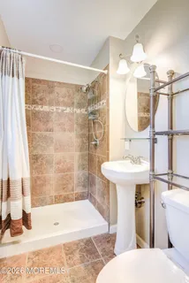a bathroom with a sink a toilet and shower