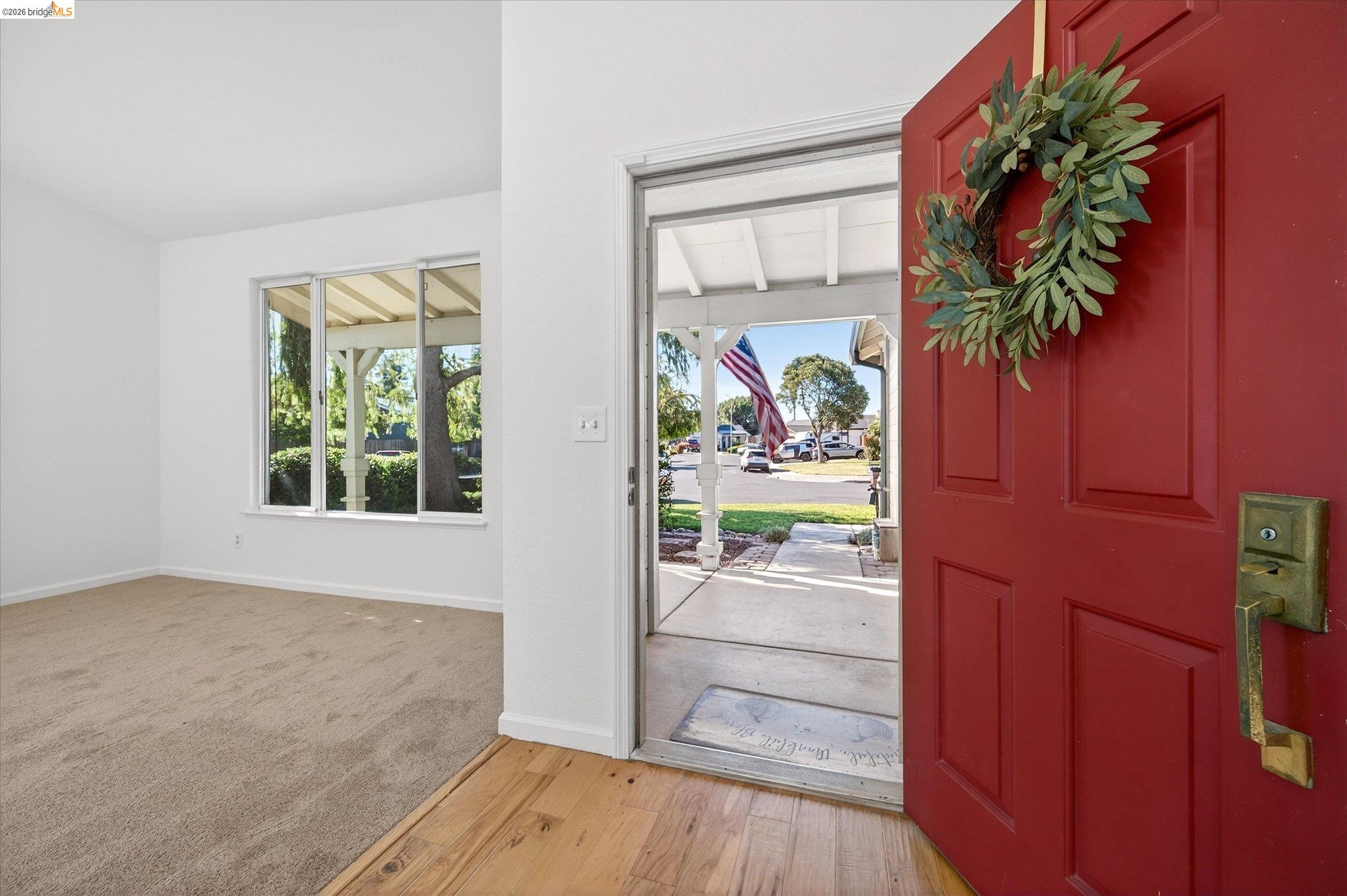 1120 Deerpark Road Oakley, CA 94561 - Photo 4 of 30 Entryway featuring a red paneled door, wood-finish flooring, and light-colored carpeting