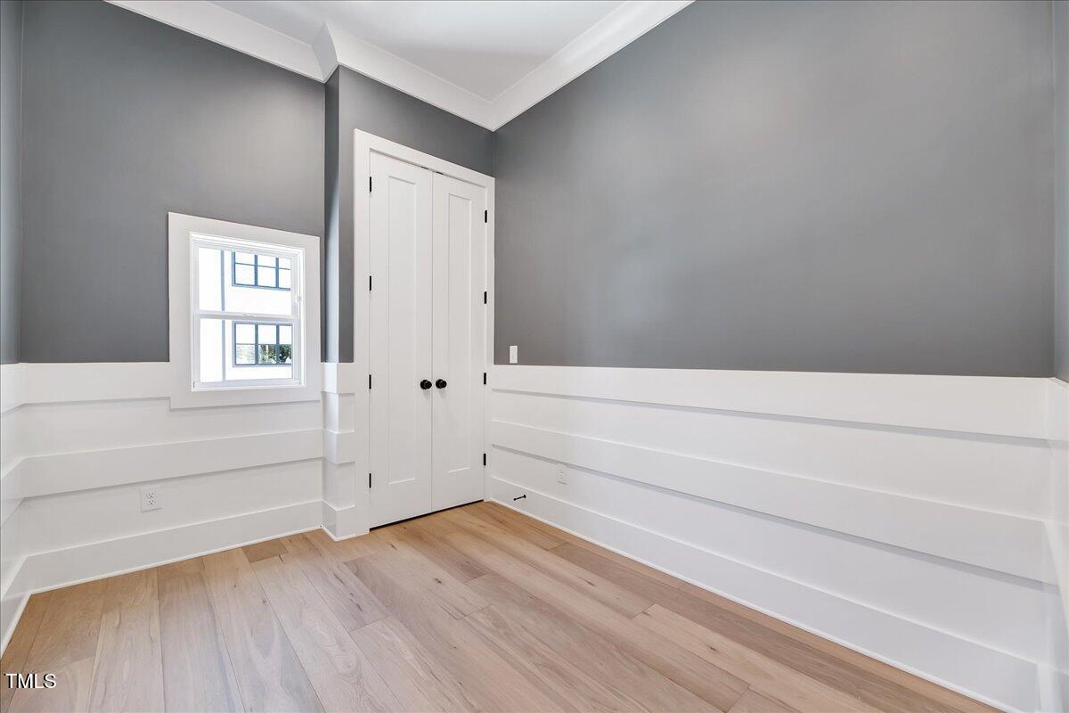811 Maple Berry Lane, Unit 106 Raleigh, NC 27607 - Photo 9 of 30 a view of an empty room with wooden floor and a window