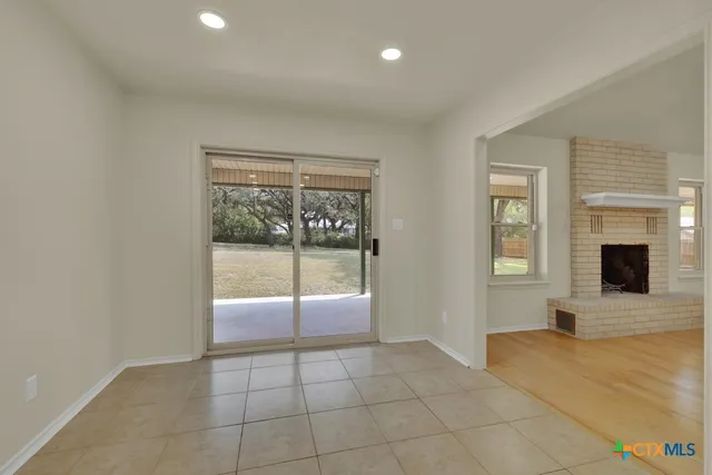 a view of an empty room with window and closet area