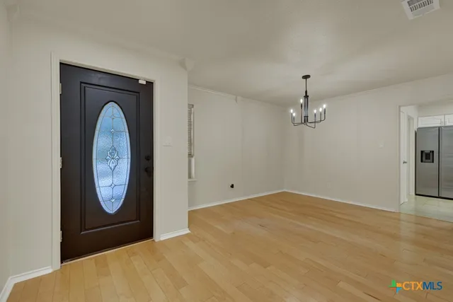 a view of an empty room with a fireplace and a window