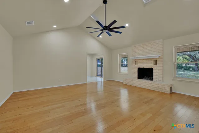 a view of an empty room with a fireplace and a window