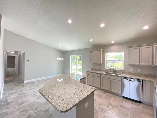 a large kitchen with kitchen island a sink stainless steel appliances and cabinets