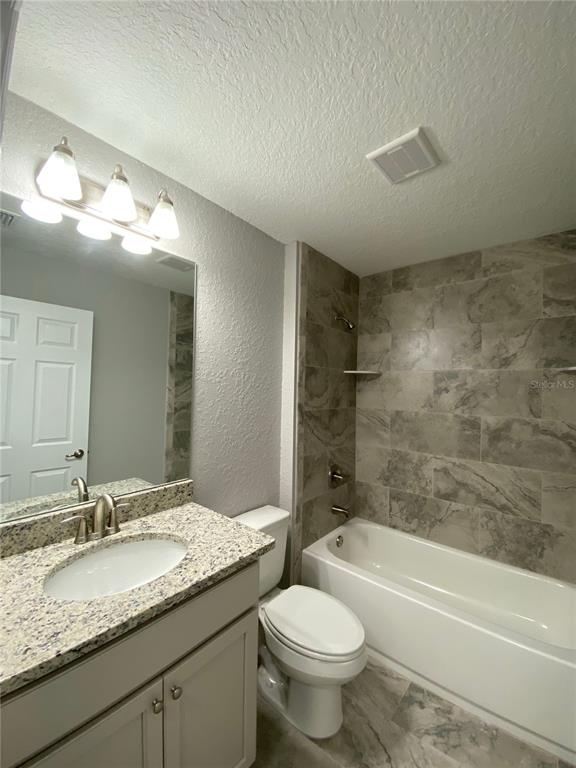 15298 Southwest 43rd Court Ocala, FL 34473 - Photo 14 of 26 a bathroom with a granite countertop sink a toilet and bathtub