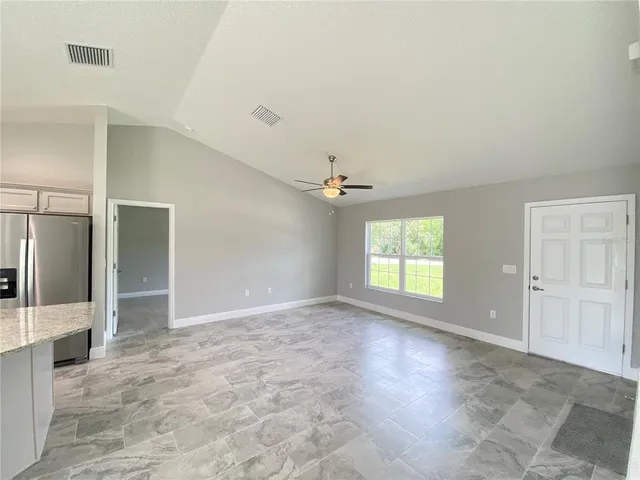 an empty room with windows and cabinet