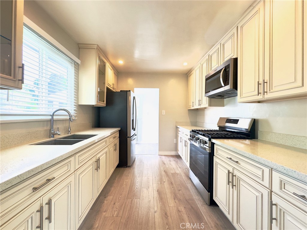 7454 Gaviota Avenue Van Nuys, CA 91406 - Photo 5 of 11 a kitchen with stainless steel appliances granite countertop a sink stove microwave and refrigerator
