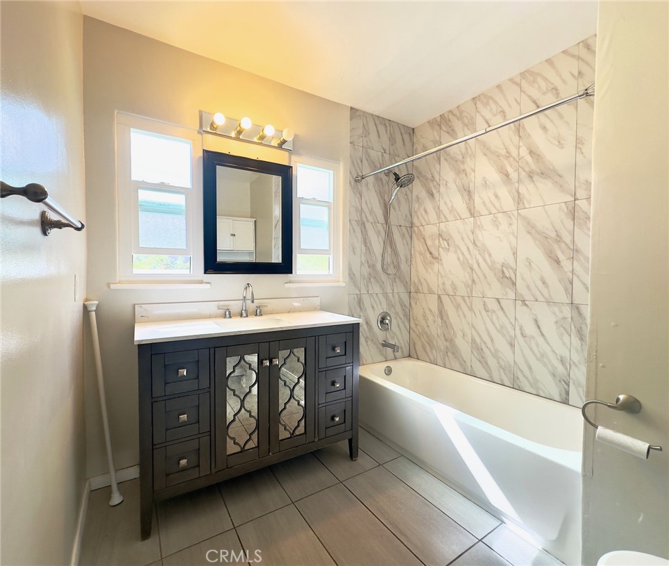 7454 Gaviota Avenue Van Nuys, CA 91406 - Photo 9 of 11 a bathroom with a sink bathtub and a mirror