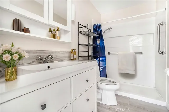 a bathroom with a sink a toilet and shower