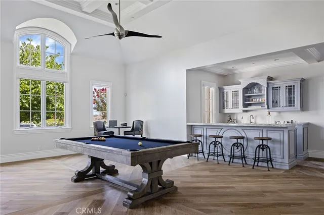 a room with chandelier fan and wooden floor