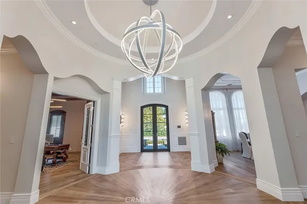 a view of a hallway with entryway dining room and chandelier