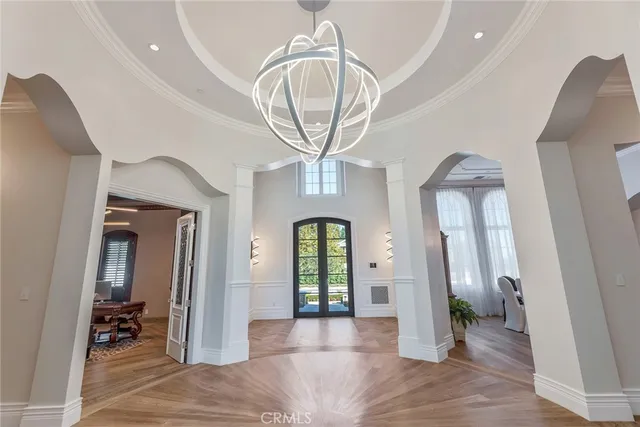 a view of a hallway with entryway dining room and chandelier