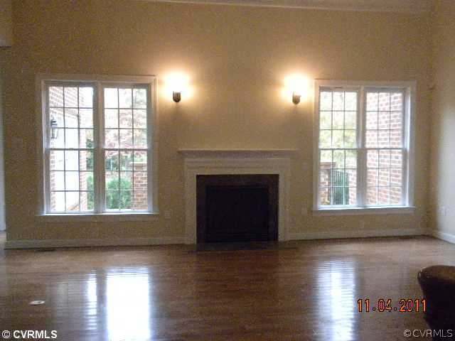 516 Hunt Field Road Manakin-Sabot, VA 23103 - Photo 7 of 9 an empty room with wooden floor fireplace and windows