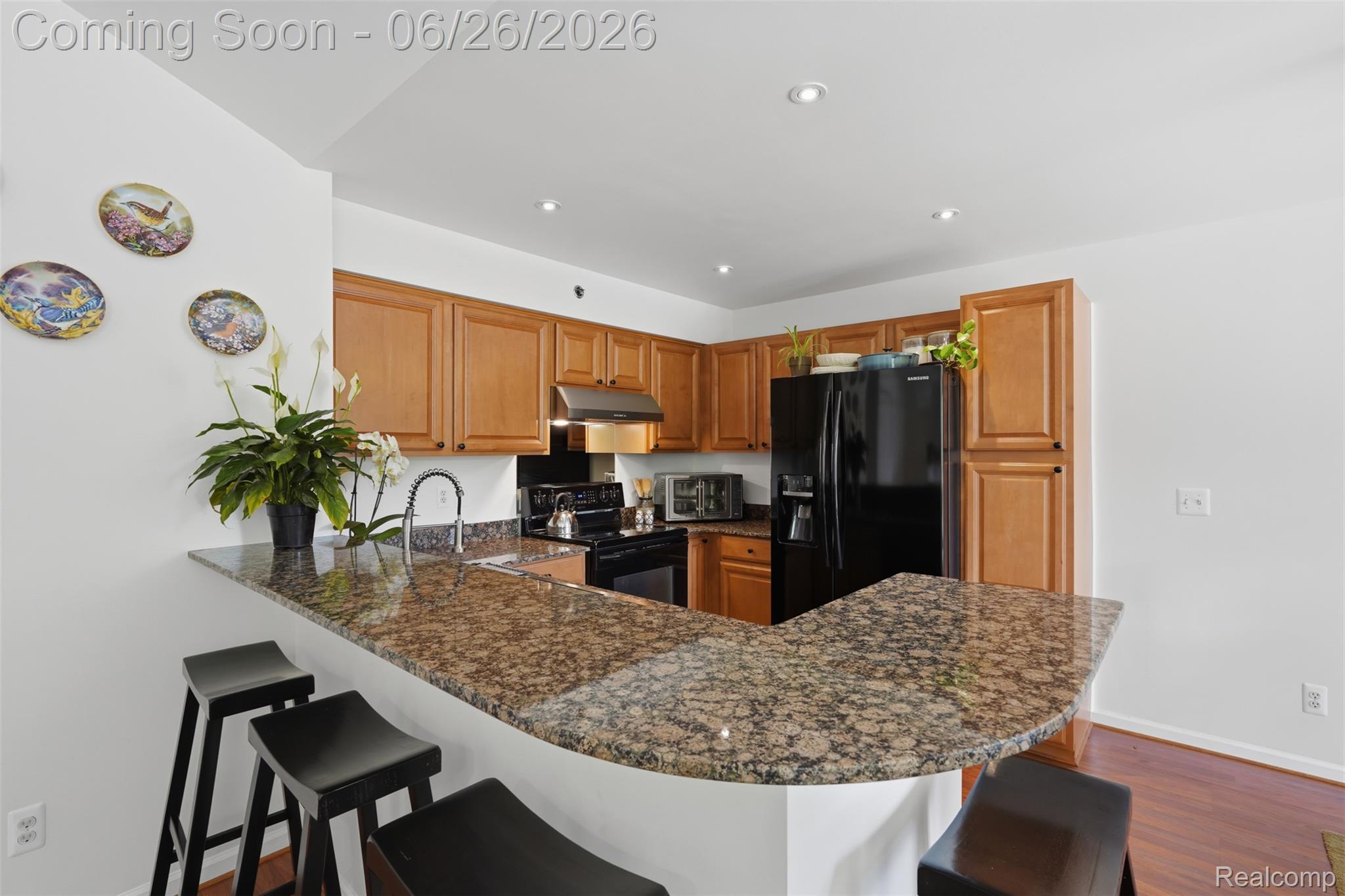 1668 Deepwood Circle Rochester, MI 48307 - Photo 15 of 27 Kitchen featuring a U-shaped granite countertop, wood-finish cabinetry, built-in black appliances, and recessed lighting