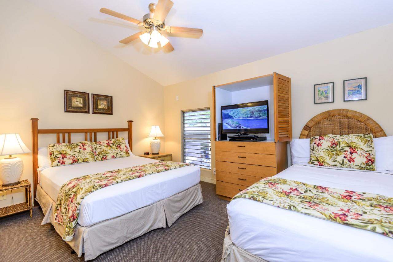 4909 Lower Honoapiilani Road, Unit E4 Lahaina, HI 96761 - Photo 15 of 30 a bedroom with a bed and a chandelier