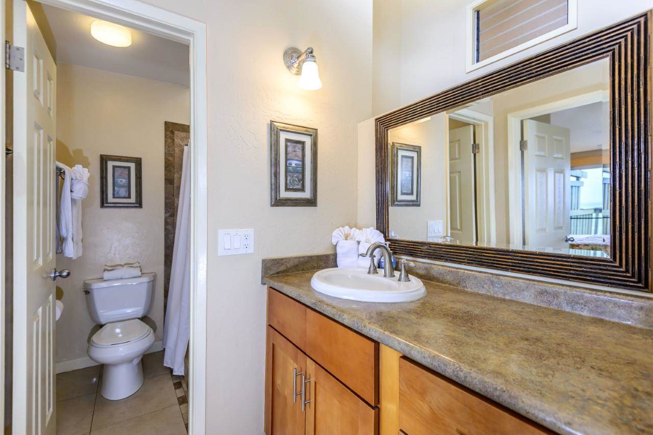 4909 Lower Honoapiilani Road, Unit E4 Lahaina, HI 96761 - Photo 9 of 30 a bathroom with a sink a toilet and mirror
