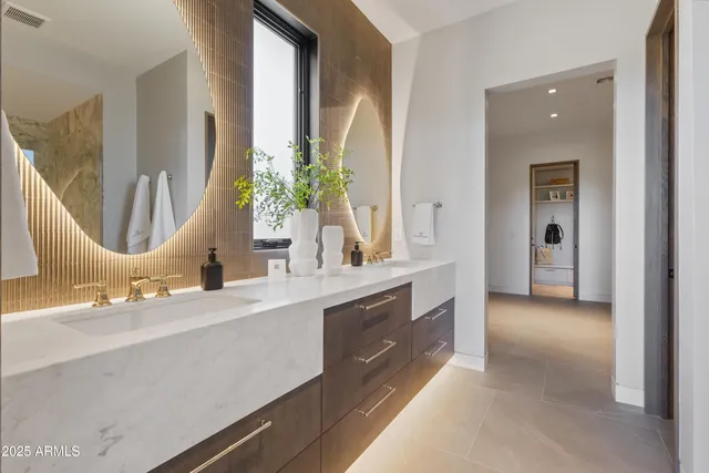 a en suite bathroom with a double vanity sink and a mirror