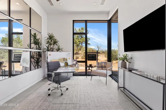 a living room with furniture a flat screen tv and a floor to ceiling window