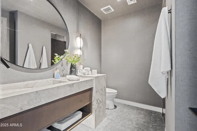 a bathroom with a sink a toilet and mirror