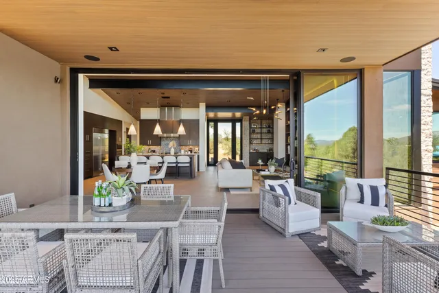a living room with furniture a large window and wooden floor
