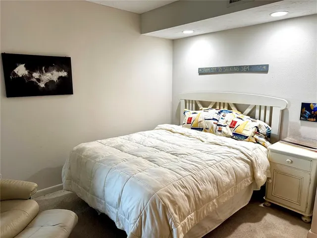 a bedroom with a bed a painting on the wall and a baby crib