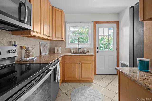 a kitchen with granite countertop a sink stove and cabinets