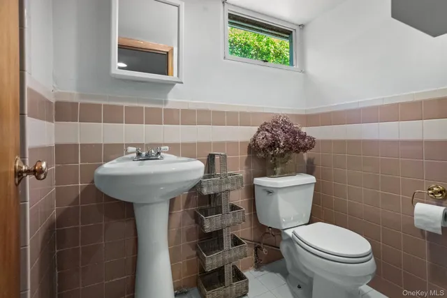 a bathroom with a toilet sink and mirror