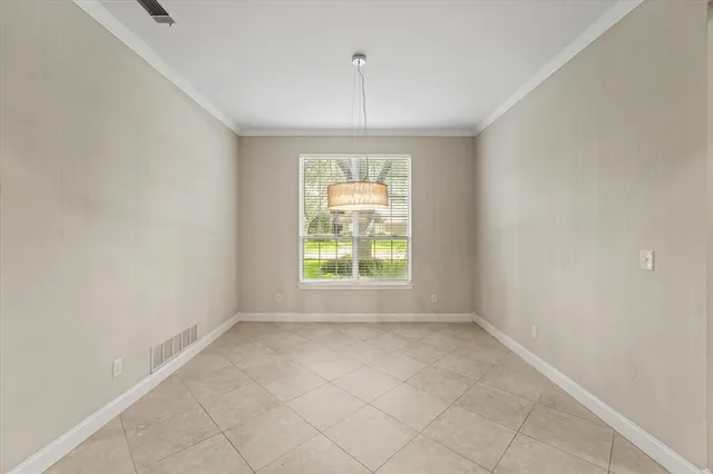 an empty room with a window and a chandelier