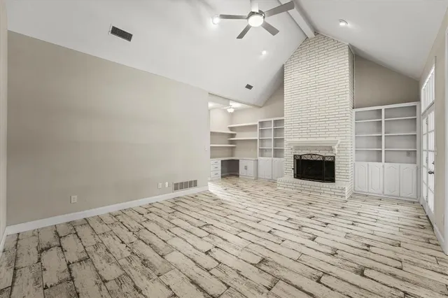 an empty room with a fireplace and chandelier