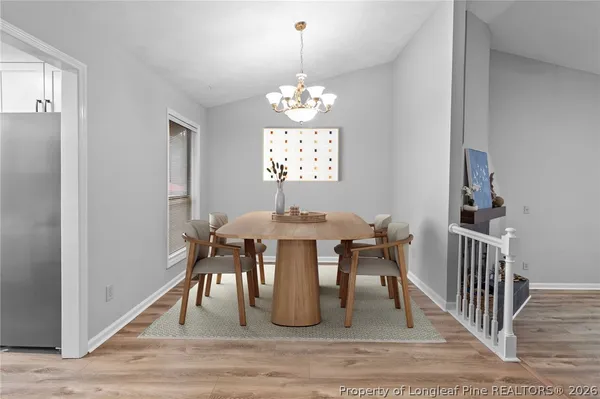 a dining room with furniture a chandelier and wooden floor