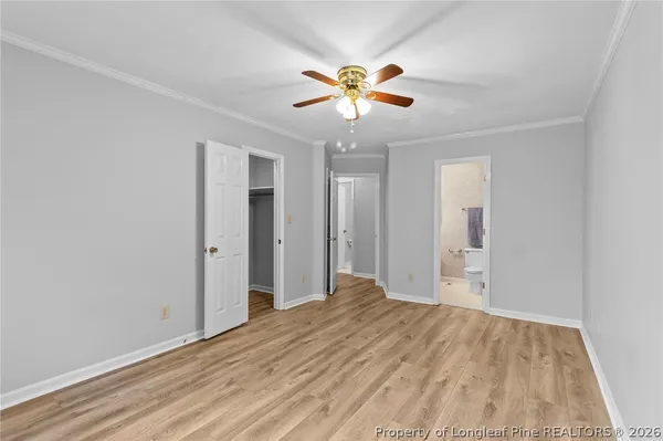 a view of a big room with wooden floor and a chandelier fan