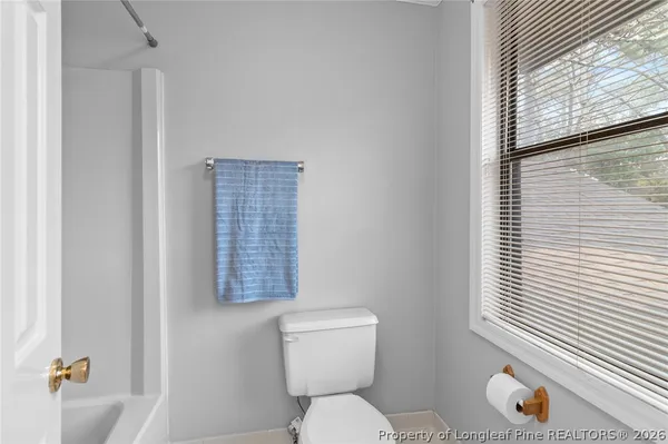 a bathroom with a toilet a sink and a window