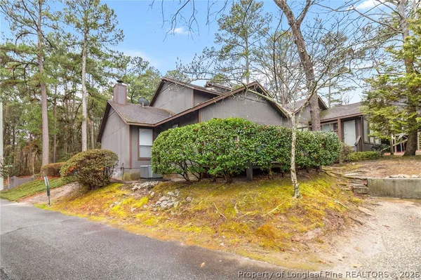 a view of a house with a large tree and plants