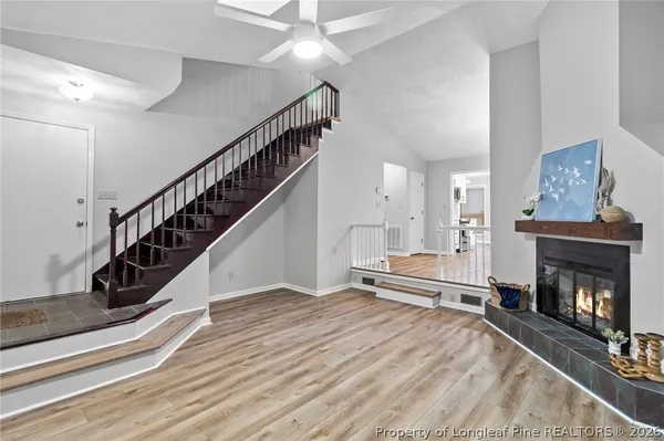 a view of a livingroom with fireplace stairs and windows