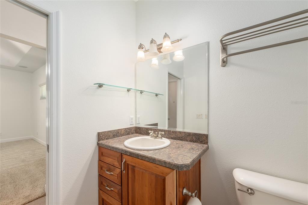 4735 Southeast 112th Street Road Belleview, FL 34420 - Photo 35 of 73 a bathroom with a granite countertop sink a mirror and a toilet